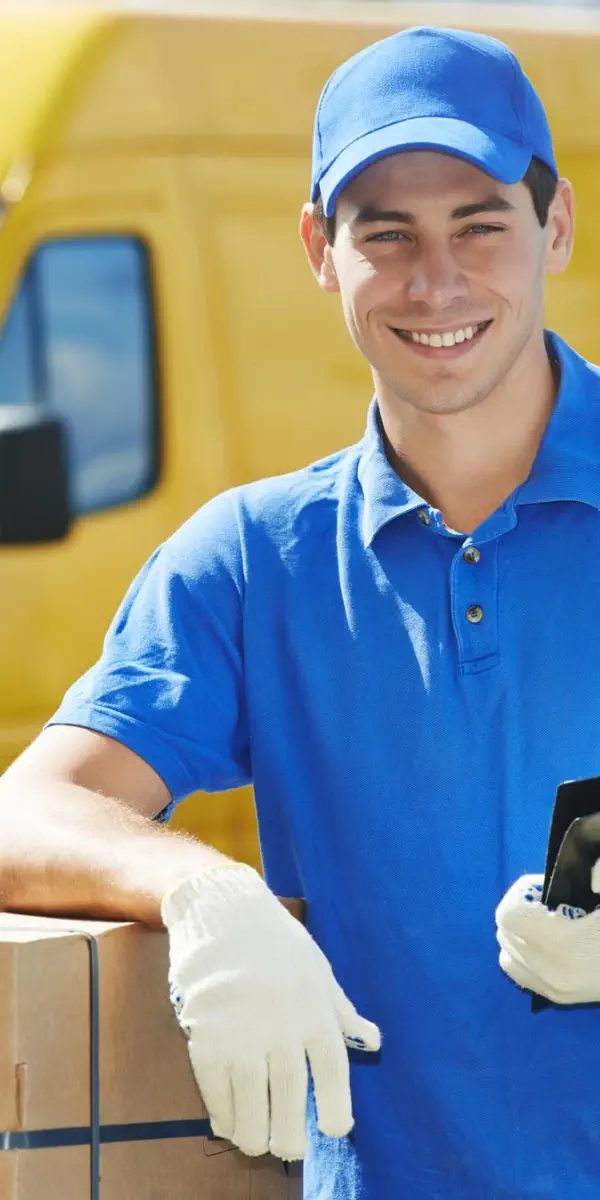 Kurierfahrer in blauem Poloshirt und Arbeitshandschuhen lehnt an einem Paket vor einem gelben Lieferwagen – Personal für Paket- und Kurierdienste